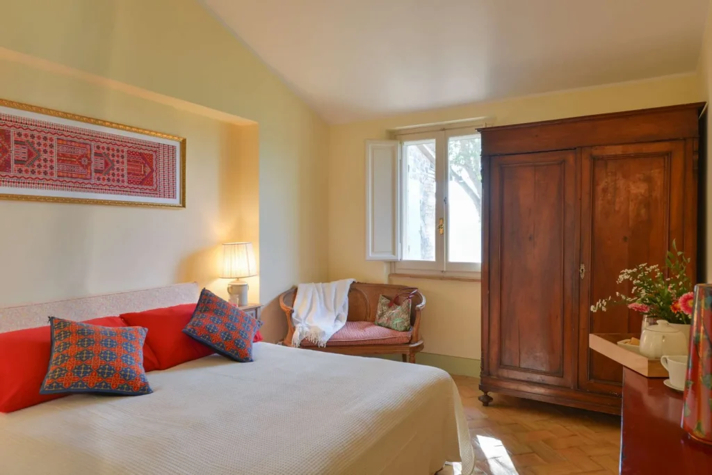 A double bedroom under a beamed ceiling with views to the valley