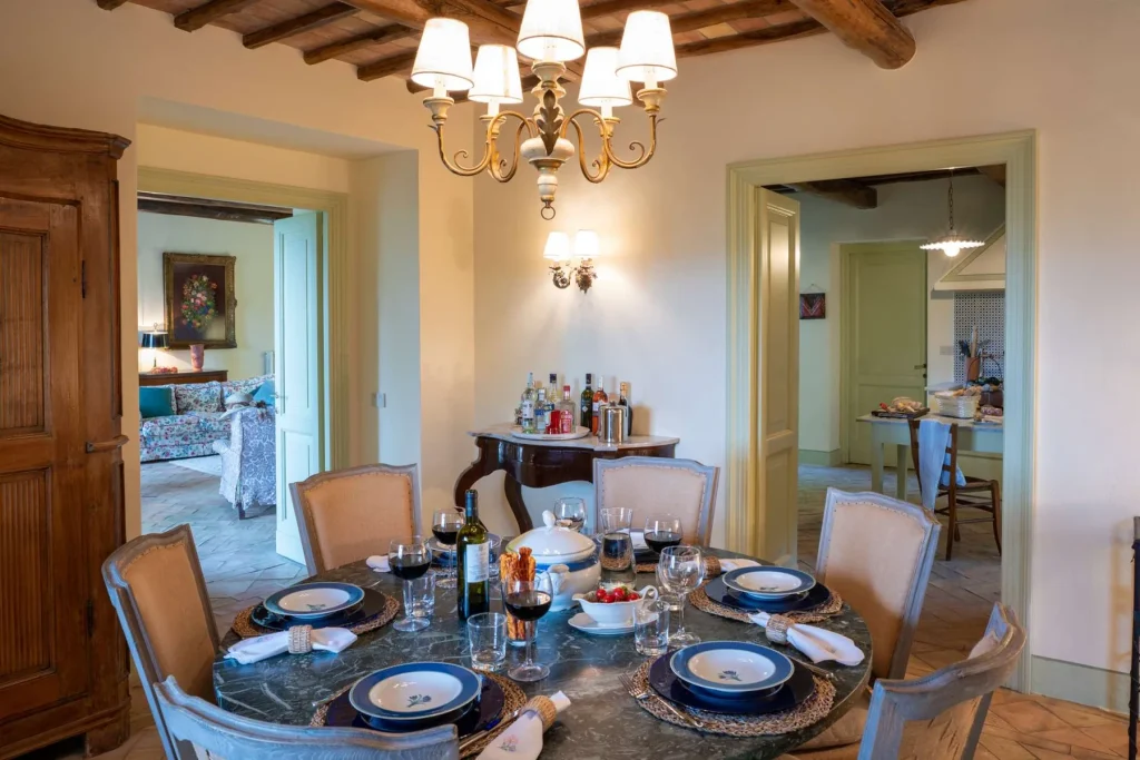 The indoor dining table laid beneath a beamed ceiling